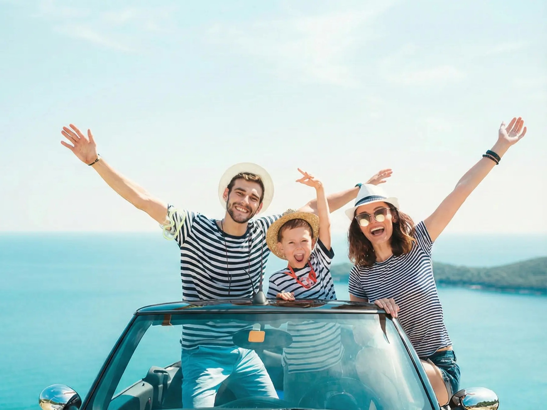 White rental SUV driving on a winding coastal road in Crete with blue sea view